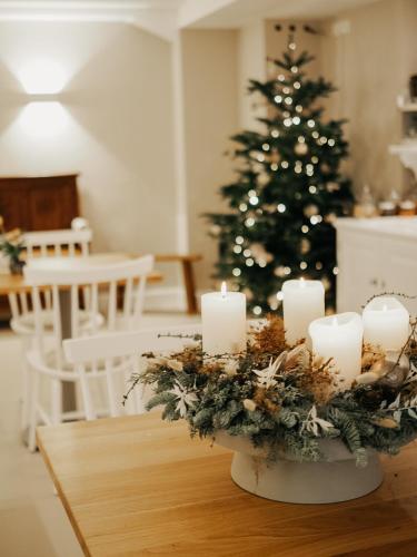a table with candles and a christmas tree in the background at Roudenhaff Guestfarm in Echternach