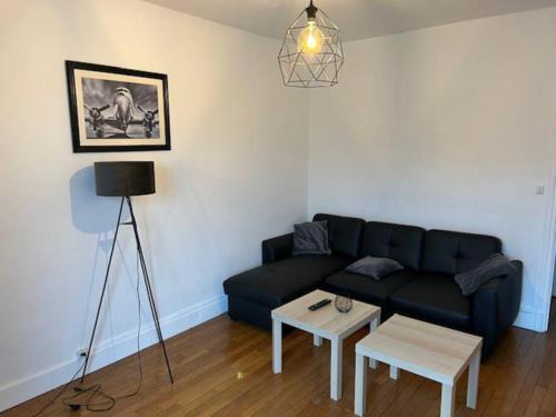 a living room with a black couch and a table at Hubert in Carignan