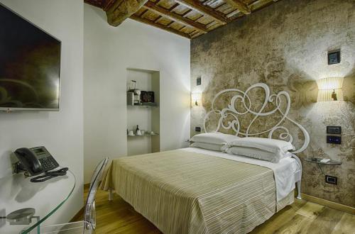 a bedroom with a bed and a desk and a phone at Deluxe Ripetta 41 in Rome