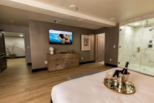 ein Schlafzimmer mit einem Bett und einem TV an der Wand in der Unterkunft The Lexi Las Vegas in Las Vegas
