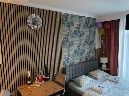 1 dormitorio con 1 cama y 1 mesa con botellas de vino en Apartament ROYAL Chełmońskiego Śrem, en Śrem