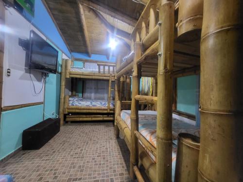 a room with three bunk beds and a television at El rancho de stella in Cali