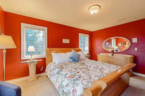a bedroom with orange walls and a bed with a mirror at Cherry Heights in The Dalles