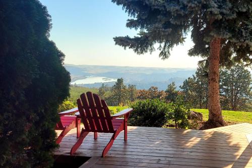 a red bench sitting on a wooden deck with a view at Cherry Heights in The Dalles