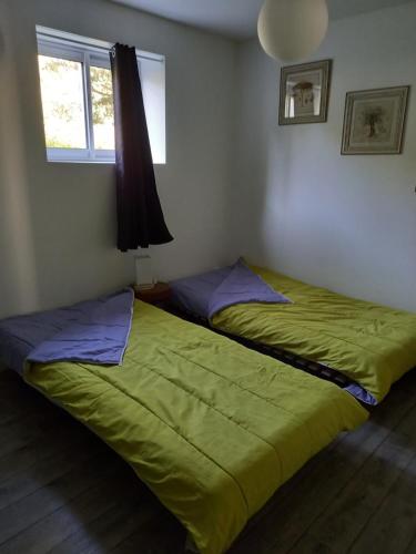 2 camas num quarto com um edredão verde em T2 rez de jardin 5 min de Cassis em Carnoux