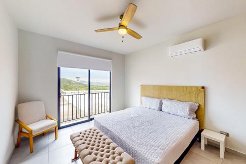 卡波聖盧卡斯的住宿－Maralta F 109，卧室配有床、椅子和窗户。