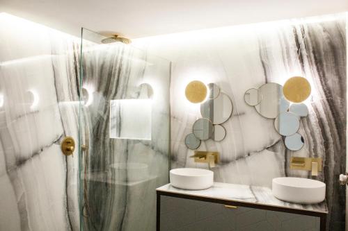 a bathroom with two sinks and mirrors on the wall at APARTAMENTO EN CALLE RECOGIDAS in Granada
