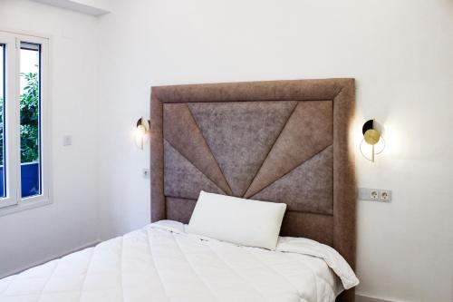 a bedroom with a white bed with a large headboard at APARTAMENTO EN CALLE RECOGIDAS in Granada