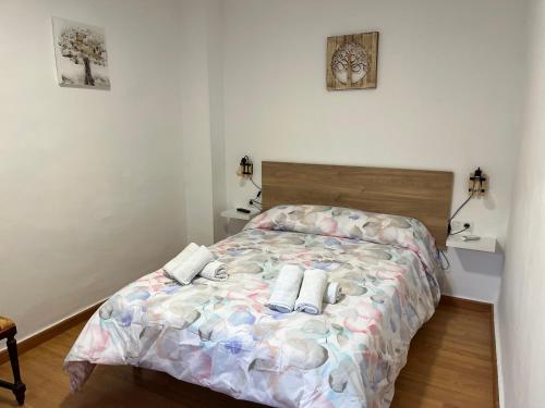 1 dormitorio con 1 cama con toallas en La Casita de Dori, en Granada