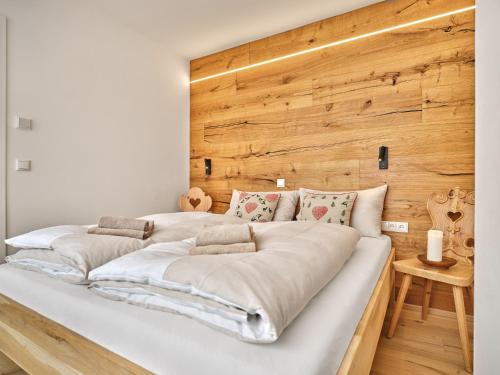 two beds in a room with a wooden wall at The Mountain Hideaway 211 by AA Holiday Homes SKI IN SKI Out Die Tauplitz in Tauplitz