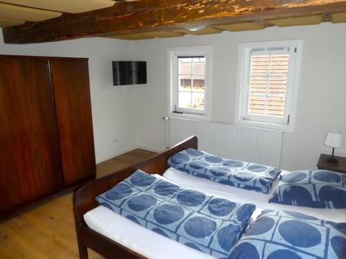2 Betten in einem Zimmer mit 2 Fenstern in der Unterkunft Alte Schreinerei in Lützelbach