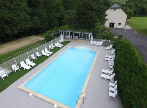 - une vue sur la piscine et ses chaises longues dans l'établissement La Grange du Devezou, à Saint-Jacques-des-Blats
