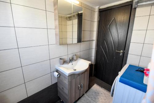 a bathroom with a sink and a mirror and a toilet at Roof Central Apartment in Kavála