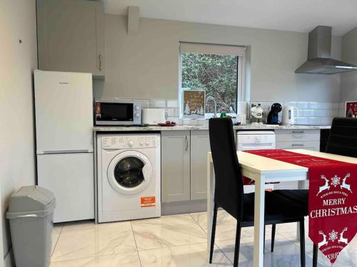 a kitchen with a washing machine and a table at Atlantic Sea View in Tralee