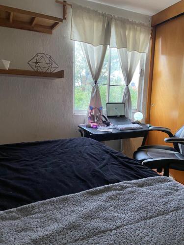 a bedroom with a bed and a desk with a laptop at Habitación en departamento muy céntrico in Mexico City