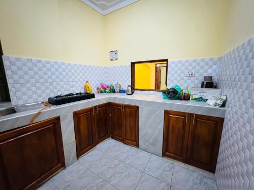 La cuisine est équipée d'un comptoir, d'un évier et d'un miroir. dans l'établissement Binga villa, à Kisoro