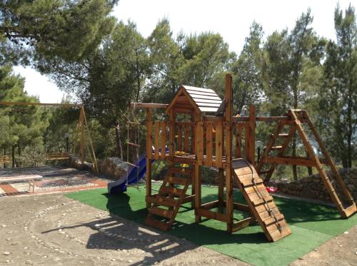 un parque infantil de madera con un tobogán y un marco de escalada en Villa Marhu' en Mattinata