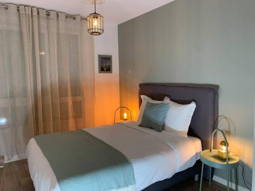 1 dormitorio con 1 cama con 2 lámparas y una ventana en La demeure des Rois - Parking - Metro - Stade de France, en Saint-Denis