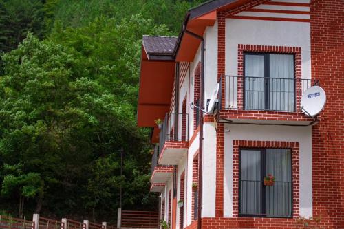 un edificio de ladrillo rojo y blanco con ventana en Holiday Borjomi en Borjomi