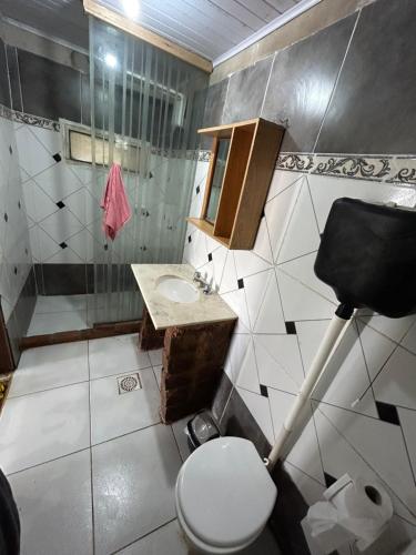 a bathroom with a toilet and a sink at Barra do chui Brasil in Santa Vitória do Palmar