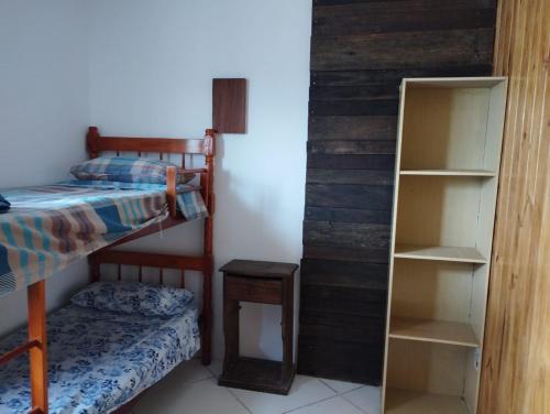 ein Schlafzimmer mit einem Etagenbett und einem Bücherregal in der Unterkunft Barra do chui Brasil in Santa Vitória do Palmar