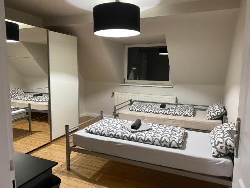 two beds in a room with a mirror at Duisburg FeelHome, Flughafen nah,2-Schlafzimmer, Badewanne, Zentral, WiFi, Top Floor in Duisburg