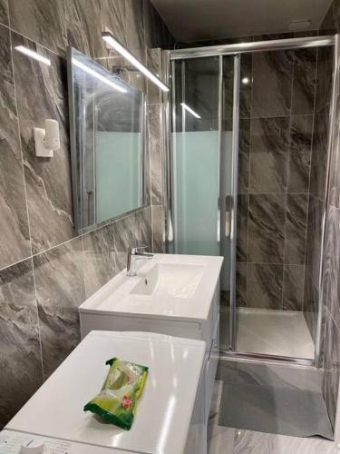 une salle de bain avec un lavabo blanc et une douche dans l'établissement Appartement neuf 15 minutes pour Paris et Orly, à Sceaux