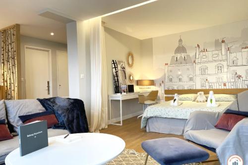 a bedroom with a bed and a couch and a table at Entre Ciel et Terre - Vue Magnifique - Loft in Caen