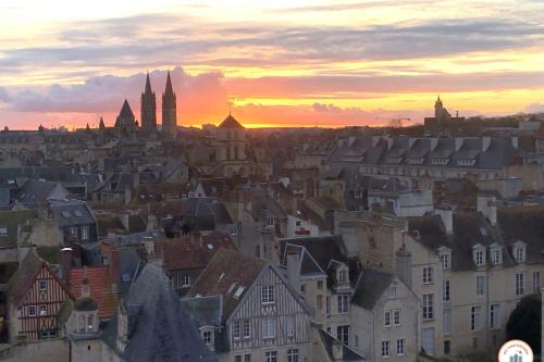 - une vue sur une ville au coucher du soleil avec des bâtiments dans l'établissement Entre Ciel et Terre - Vue Magnifique - Loft, à Caen