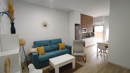 sala de estar con sofá azul y cocina en Apartamento Flor de Córdoba en Córdoba