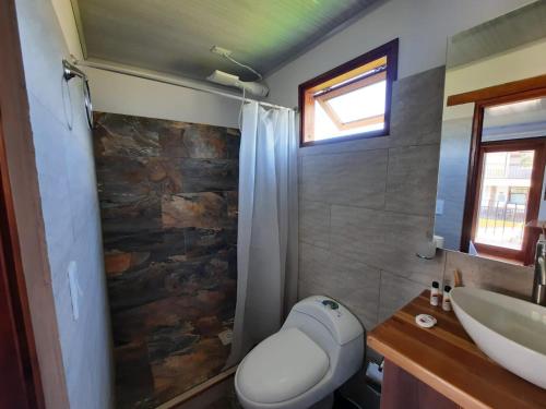 a bathroom with a toilet and a sink at Hotel Pliosaurio Campestre in Villa de Leyva