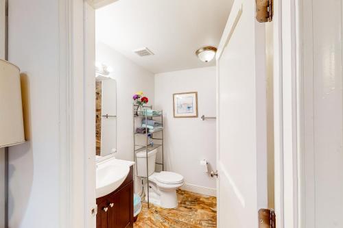 a bathroom with a toilet and a sink at Old Northwood Cottage - A in West Palm Beach