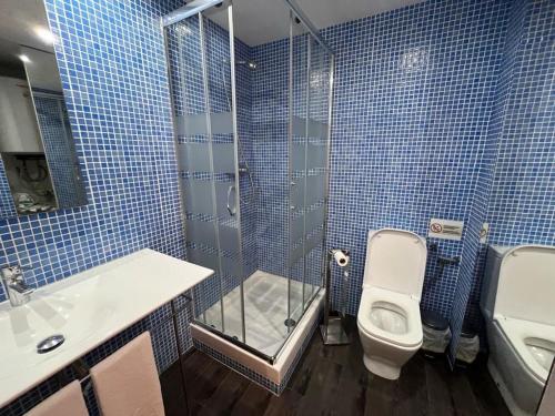 a blue tiled bathroom with a toilet and a shower at Casa vacanze appartamento Ibiza città in Ibiza Town