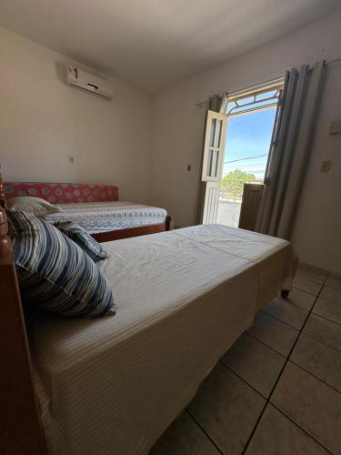 Un dormitorio con una cama grande y una ventana en Ap Br367 Porto, en Porto Seguro