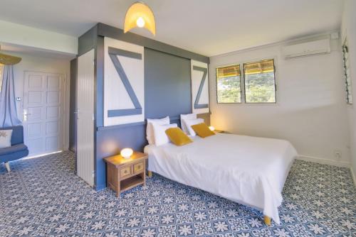 1 dormitorio con cama, mesa y ventanas en Domaine de l'Anse Ramier, en Les Trois-Îlets