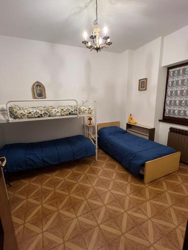 a bedroom with two bunk beds and a chandelier at Casa del Sole in Castione della Presolana