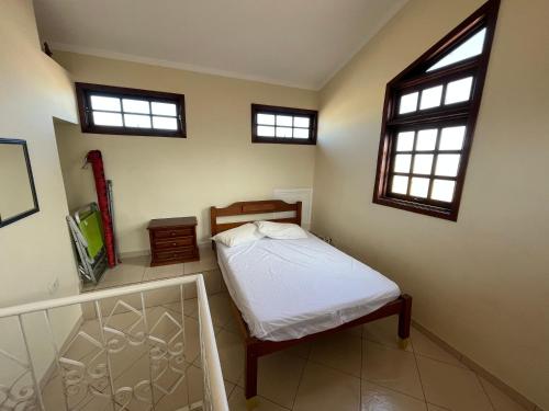 En eller flere senger på et rom på Casa aconchegante com ar condicionado para família em condomínio