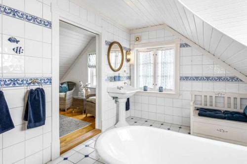 Baño blanco con lavabo y bañera en Koselig hus ved sjøen, 