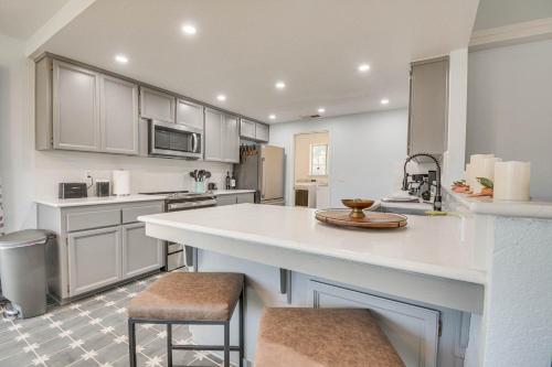 a kitchen with a large white counter and stools at Bright and Cozy Mariposa Getaway 46 Mi to Yosemite! in Mariposa