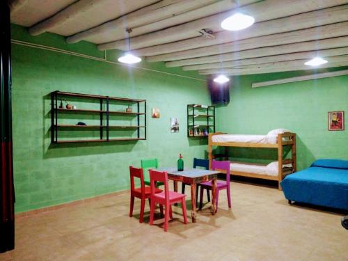 Cette chambre comprend une table, des chaises et un lit. dans l'établissement El Escarabajo Azul loft & Arte, à Villa Carlos Paz