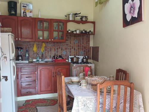 a kitchen with a table and a kitchen with a refrigerator at PeachBloom Tereace Inn in DʼArbeau