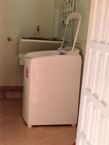 a small white refrigerator in a room with a door at PeachBloom Tereace Inn in DʼArbeau