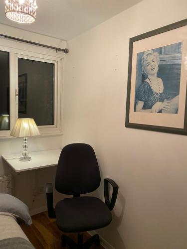a bedroom with a chair and a picture on the wall at 1 Cozy Single Bedroom With Hot Drinks in Reading