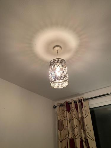 a chandelier hanging from a ceiling in a room at 1 Cozy Single Bedroom With Hot Drinks in Reading