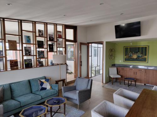 ein Wohnzimmer mit einem blauen Sofa und Stühlen in der Unterkunft Zamora Exclusive By Mr W in Mexiko-Stadt
