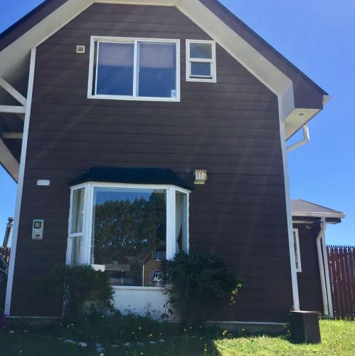 een huis met een groot raam aan de zijkant bij La casa de Rosy in Puerto Varas