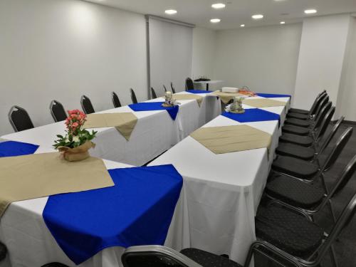 una sala de conferencias con mesas y sillas azules y blancas en Café Hotel Medellín, en Medellín