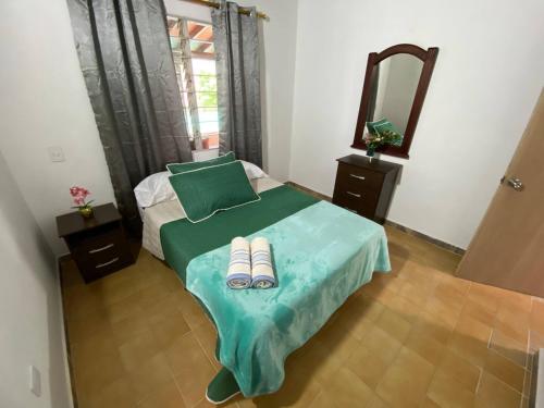 a bedroom with a bed with a mirror and slippers at Casa Finca San Nicolas in Sabaneta