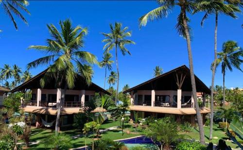 un complexe avec des palmiers et une piscine dans l'établissement Dream Beach Cumbuco Superior Oceanfront Apartments, à Cumbuco