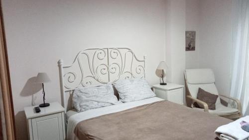 een slaapkamer met een wit bed en een stoel bij EnFOZ PLAYAS ÚNICAS Y DIVINAS! in Foz